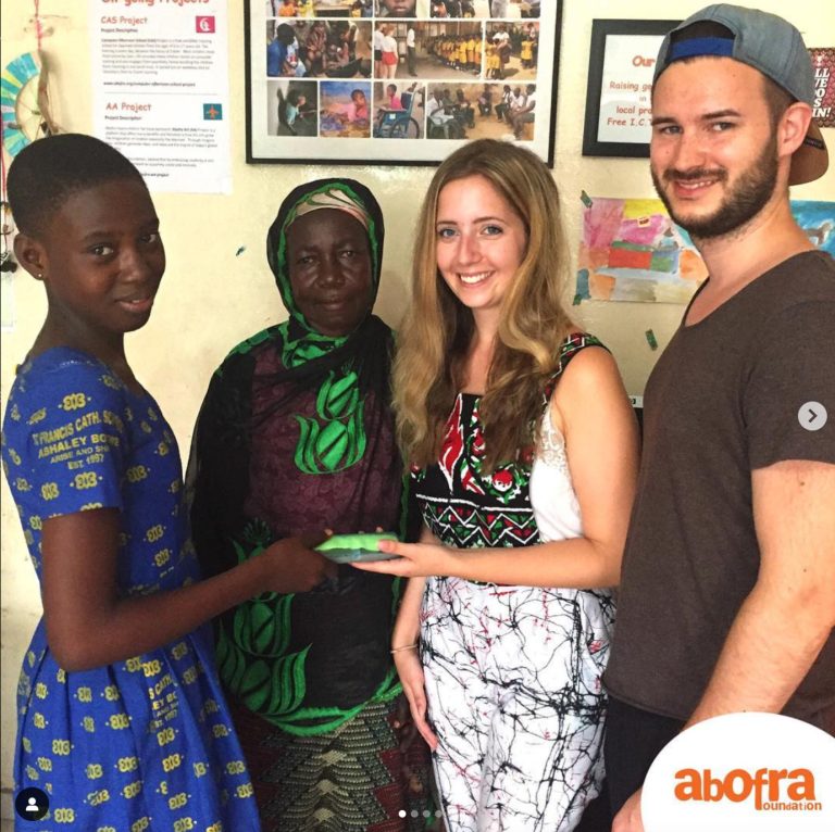 Cathy and Jonas presenting a Medical glass to Emmanuella, by her his her mother.